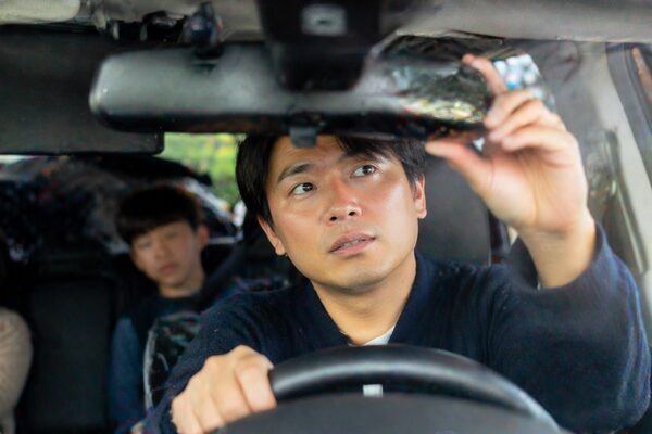 後部座席の乗員やフリップダウンモニターで後方視界が遮られている車内の様子（ルームミラーで見えにくい状態）