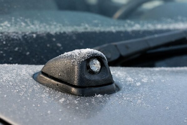 冬の朝に凍結してウォッシャー液が出ない車のノズル部分のクローズアップ